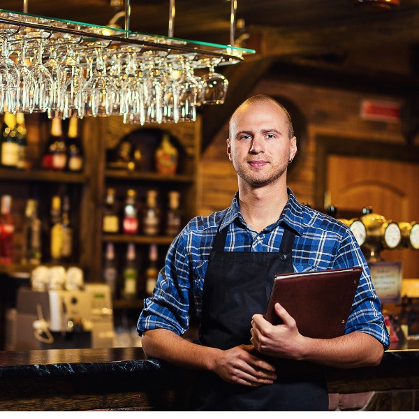 general manager standing in front of bar in his pub