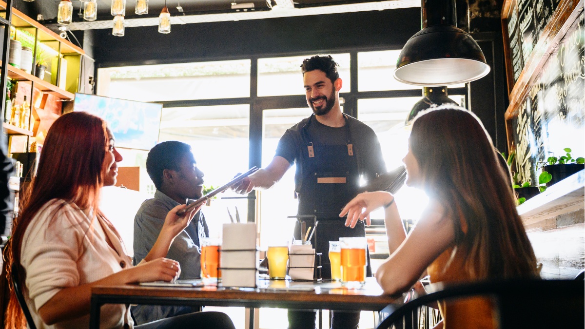 Waiter handing out menus in a restaurant